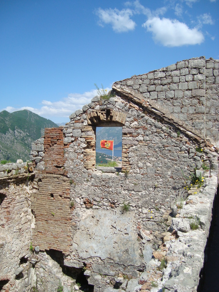 Montenegrin flag through fortress window.